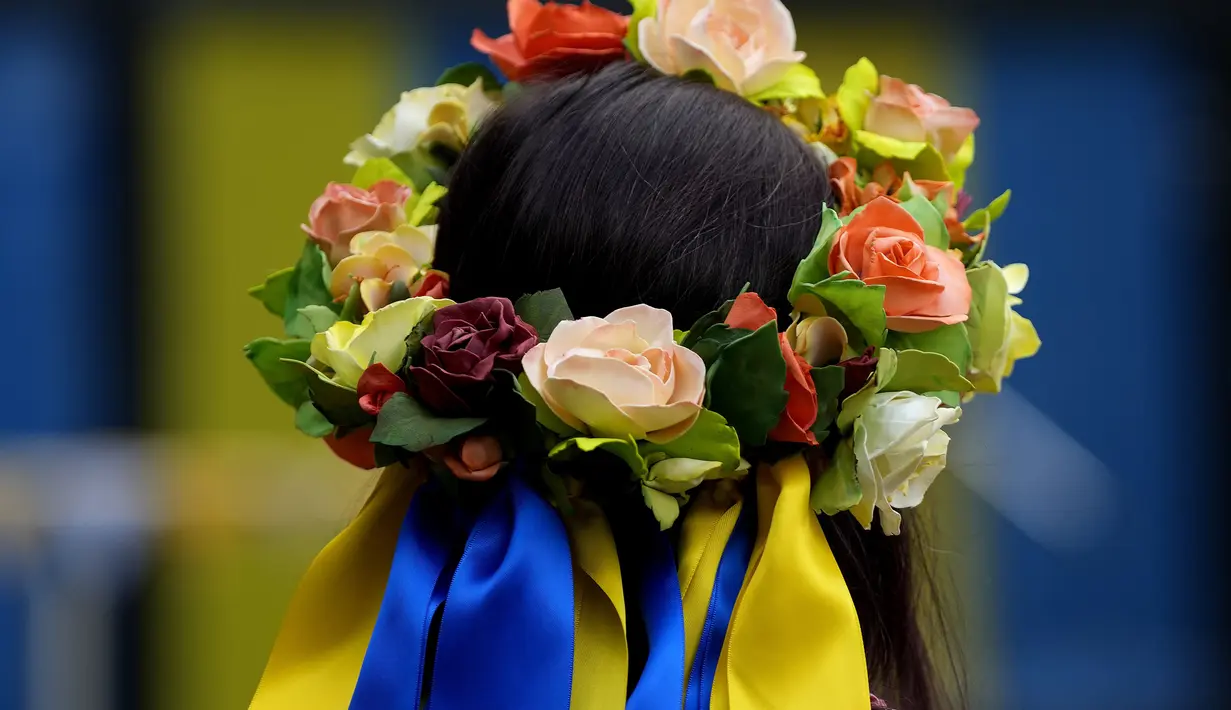 Seorang perempuan dengan hiasan rambut warna nasional Ukraina mengambil bagian pada perayaan hari Kemerdekaan Ukraina di sebuah perayaan di Chichester, Inggris selatan, Sabtu, 27 Agustus 2022. Chichester dinobatkan sebagai daerah paling dermawan di negara itu untuk menampung pengungsi Ukraina. (AP Photo/Frank Augstein)