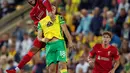 Bek Liverpool Joe Gomez menyundul bola saat bersaing dengan gelandang Norwich City Christos Tzolis pada babak ketiga Piala Liga Inggris di Carrow Road, Rabu (22/9/2021) dinihari WIB. Liverpool sukses menghajar Norwich City tiga gol tanpa balas di kandang lawan. (ADRIAN DENNIS / AFP)