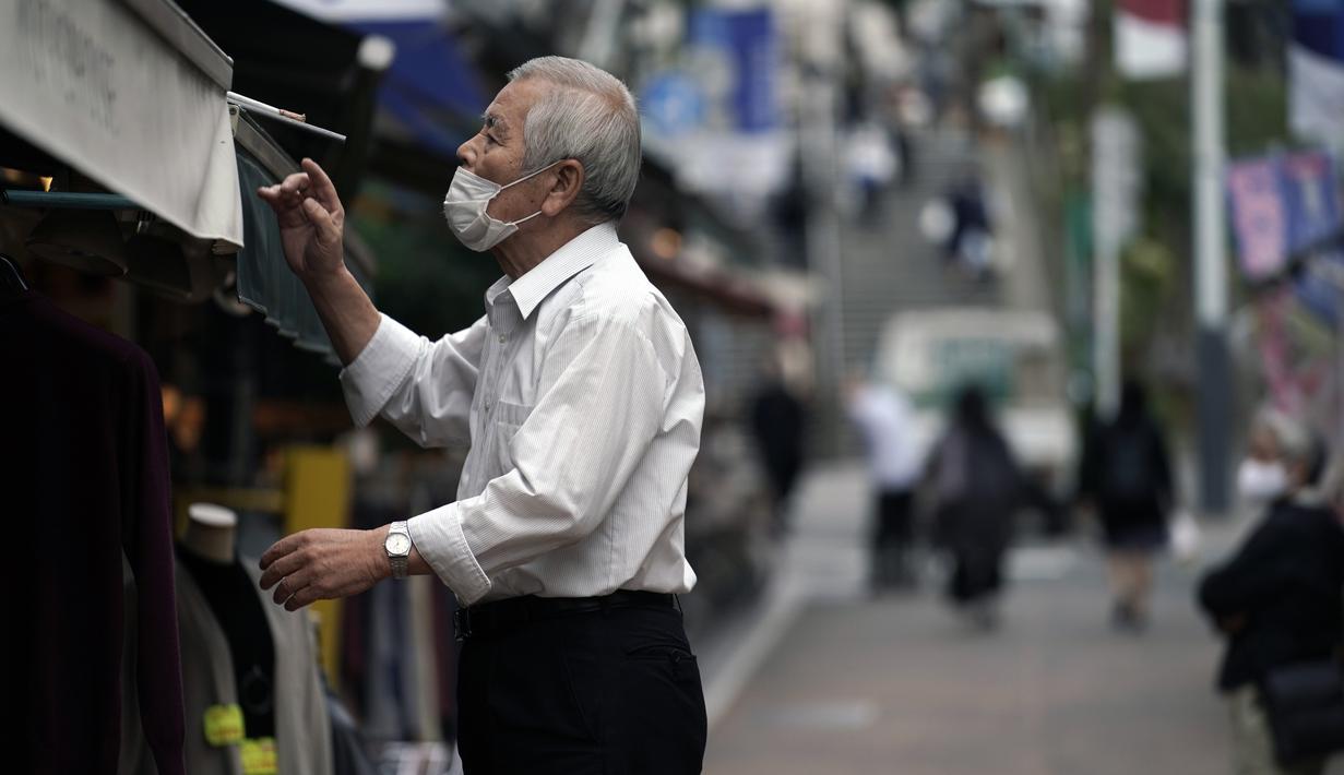 Seorang pria yang mengenakan masker pelindung untuk membantu mengekang penyebaran virus corona bekerja di sebuah toko di Tokyo, Rabu, Jepang, Rabu (14/10/2020). Tokyo mengonfirmasi lebih dari 170 kasus virus corona baru pada hari Rabu. (AP Photo/Eugene Hoshiko)