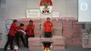 Petugas merapikan tumpukan uang sebesar Rp 300 miliar yang dipamerkan di gedung Merah Putih Komisi Pemberantasan Korupsi (KPK), Jakarta, Kamis (20/11/2025). (Liputan6.com/Helmi Fithriansyah)