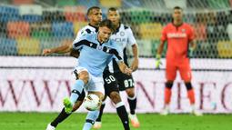 Penyerang Lazio, Ciro Immobile, berebut bola dengan bek Udinese, Rodrigo Becao, pada laga lanjutan Serie A pekan ke-33 di Dacia Arena, Kamis (16/7/2020) dini hari WIB. Lazio bermain imbang 0-0 atas Udinese. (AFP/Miguel Medina)