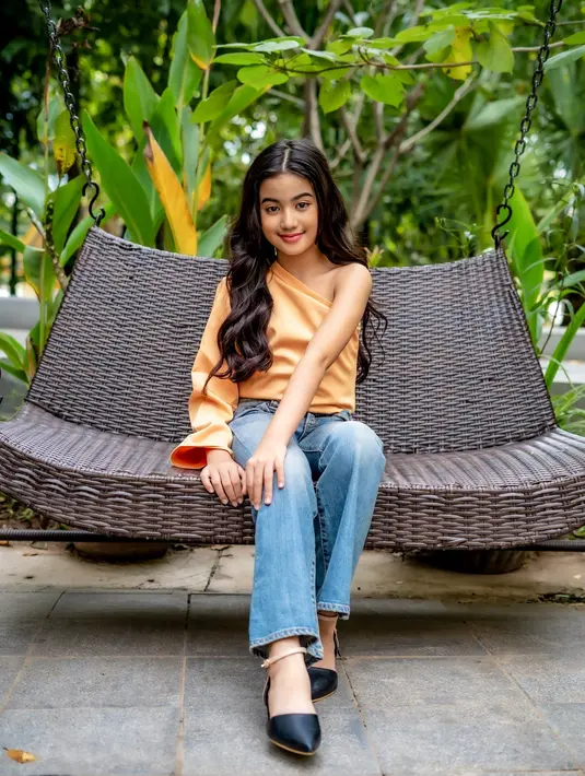 Gaya ikonis Putri Diana lainnya adalah outfit one shoulder. Begitu juga anggota keluarga Kerajaan Kamboja berusia 9 tahun yang cukup sering memakai potongan one shoulder baik dalam look etnik atau modern (Foto: Facebook Princess Jenna Norodom)