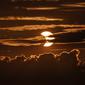 Gerhana matahari sebagian muncul di balik awan, Arbutus, Md, Kamis (10/6/2021).  (AP Photo/Julio Cortez)