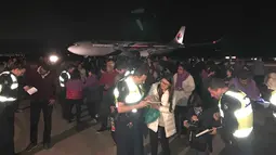 Foto yang mengambarkan situasi para penumpang berada di depan Malaysia Airlines Flight MH128 di Melbourne, Australia (1/6). Pesawat itu terpaksa kembali setelah seorang penumpang mengklaim memiliki bom dan memaksa masuk kokpit. (Andrew Leconcelli/AFP)