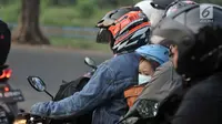 Seorang bocah membonceng sepeda motor diapit ayah dan ibunya di Jalur Kalimalang, Bekasi, Jawa Barat, Rabu (13/6). Kendaraan pemudik yang didominasi roda dua saling berhimpitan di tengah barang bawaan masing-masing. (Merdeka.com/Iqbal S. Nugroho)