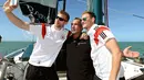 Pemain Timnas Jerman, Per Mertesacker (kiri) dan Benedikt Hoewedes berfoto bersama dengan petualang Mike Horn (tengah) di atas kapal saat berlayar di salah satu pantai dekat Santo Andre, Sao Paolo, Brasil, (10/6/2014). (AFP PHOTO/Markus Gilliar) 