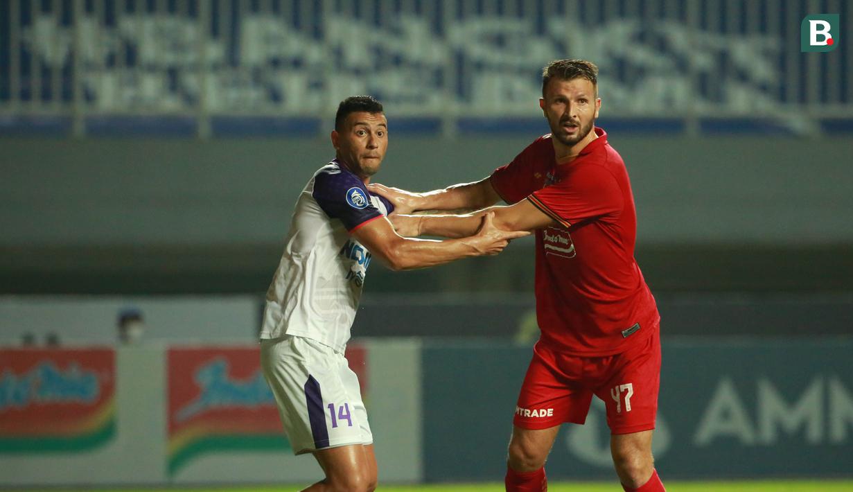 Pemain Persija Jakarta, Marco Motta (kanan) dijaga ketat oleh pemain Persita, Alex Dos Santos Goncalves pada pertandingan pekan kelima BRI Liga 1 di Stadion Pakansari, Selasa (28/9/2021). (Bola.com/ M Iqbal Ichsan)