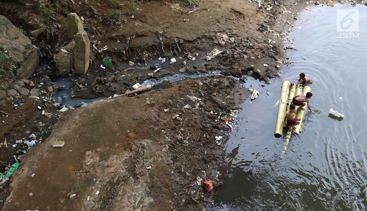 Anak-anak berenang menggunakan batang pohon pisang di bantaran Sungai Ciliwung, Jakarta, Selasa (15/5). Aktivitas tersebut berbahaya bagi kesehatan dan keselamatan mereka. (Liputan6.com/Immanuel Antonius)