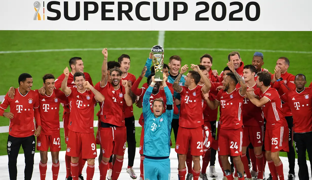 Penjaga gawang Bayern Munchen Manuel Neuer dan rekan satu timnya merayakan dengan trofi juara Piala Super Jerman usai mengalahkan Borussia Dortmund di Munich, Jerman, 30 September 2020. (Photo by ANDREAS GEBERT / POOL / AFP)