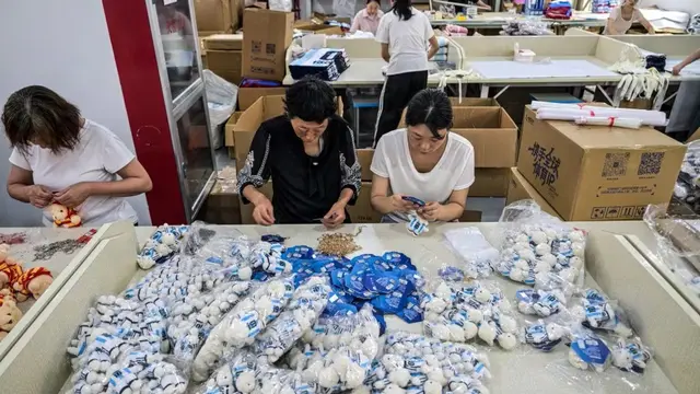 Para pekerja mengemas merchandise tim nasional sepak bola Argentina bergambar Lionel Messi