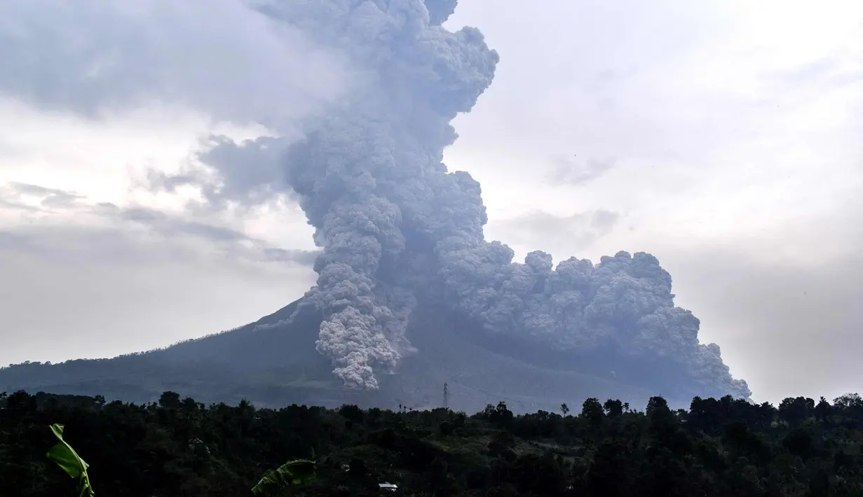 Gunung Sinabung yang mengeluarkan abu tebal terlihat dari kota Karo, Sumatera Utara (6/4). Letusan melontarkan abu vulkanik dan material piroklastik dengan tekanan kuat berwarna abu-abu gelap hingga setinggi 5.000 meter. (AFP Photo/Anto Sembiring)