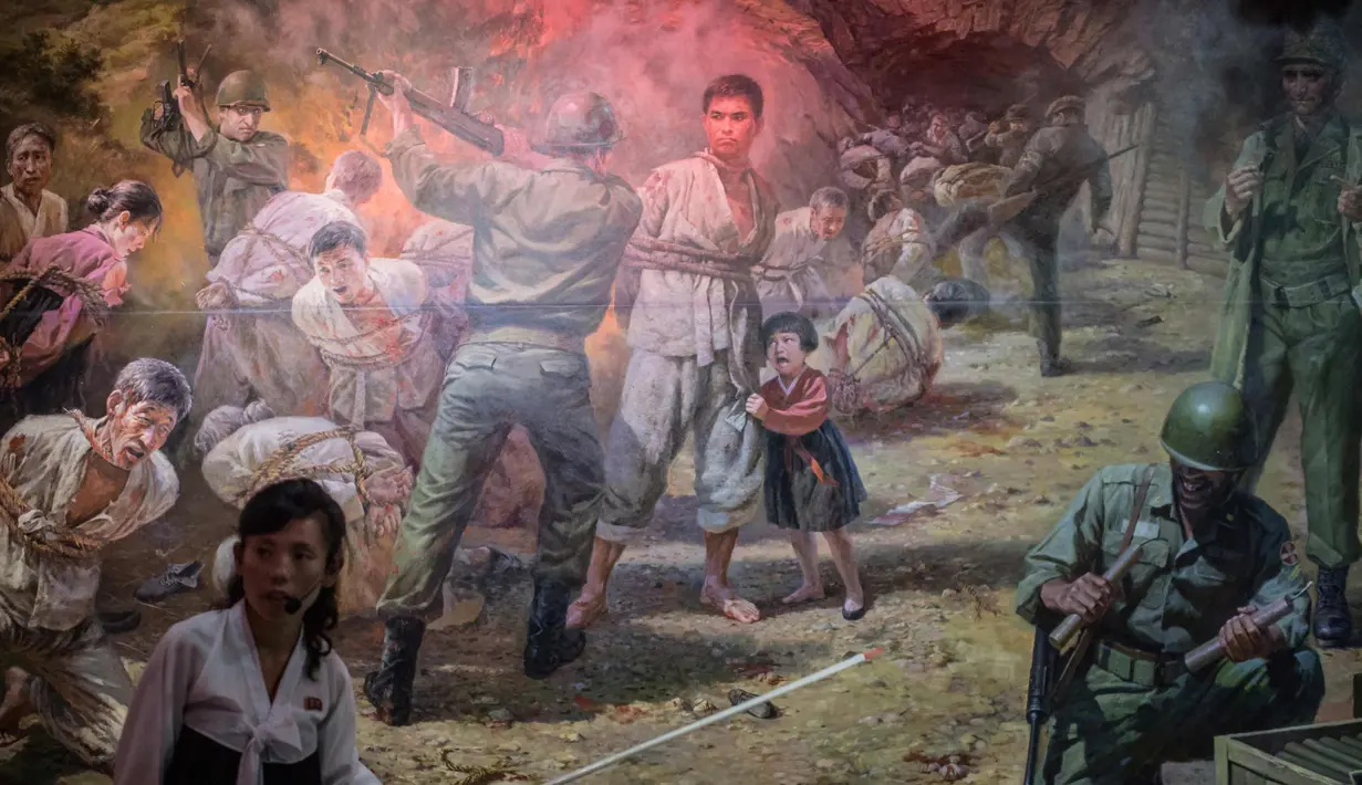 Pemandu menunjukkan lukisan di Sinchon Museum of American War Atrocities di Pyongyang 24 Juli 2017. Museum ini untuk mengenang kematian lebih dari 35,000 orang dari 17 Oktober sampai 7 Desember 1950. (AFP Photo/Ed Jones)