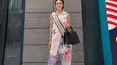 Puteri Indonesia 2023 Farhana Nariswari tampil cantik mengenakan batik bersiluet modern. Inner putih ditumpuk dengan outer batik berkerah tanpa lengan bernuansa merah muda yang lembut, dikombinasikan dengan midi pants dengan pita di bagian bawah. [Foto: Instagram/farhanariswari]