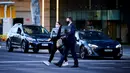Orang-orang membawa monitor komputer untuk bekerja dari rumah di Canberra, Australia, Kamis (12/8/2021). Canberra melakukan lockdown selama tujuh hari setelah satu kasus COVID-19 terdeteksi. (Rohan Thomson/AFP)