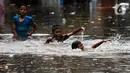 Sejumlah anak bermain saat banjir melanda kawasan Kemang Utara, Jakarta, Kamis (4/1/2024).(Liputan6.com/Herman Zakharia)