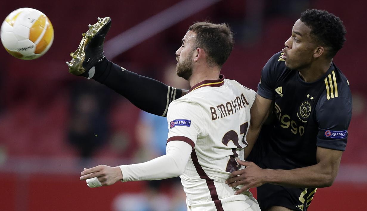 Bek Ajax Amsterdam, Jurrien Timber (kanan) berebut bola dengan striker AS Roma, Borja Mayoral dalam laga leg pertama perempatfinal Liga Europa 2020/2021 di Johan Cruijff Arena, Amsterdam, Kamis (8/4/2021). Ajax kalah 1-2 dari AS Roma. (AP/Peter Dejong)