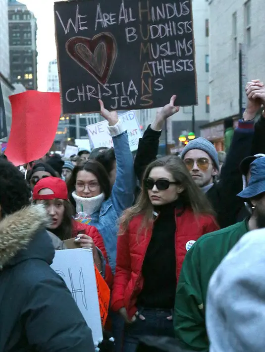 Melihat papan yang dibawa Bella dan Gigi saat demo, terdapat beberapa huruf yang memiliki warna berbeda dari setiap kata di papan itu yang kemudian menjadi tulisan ‘We Are All Humans’. (doc.dailymail.com)