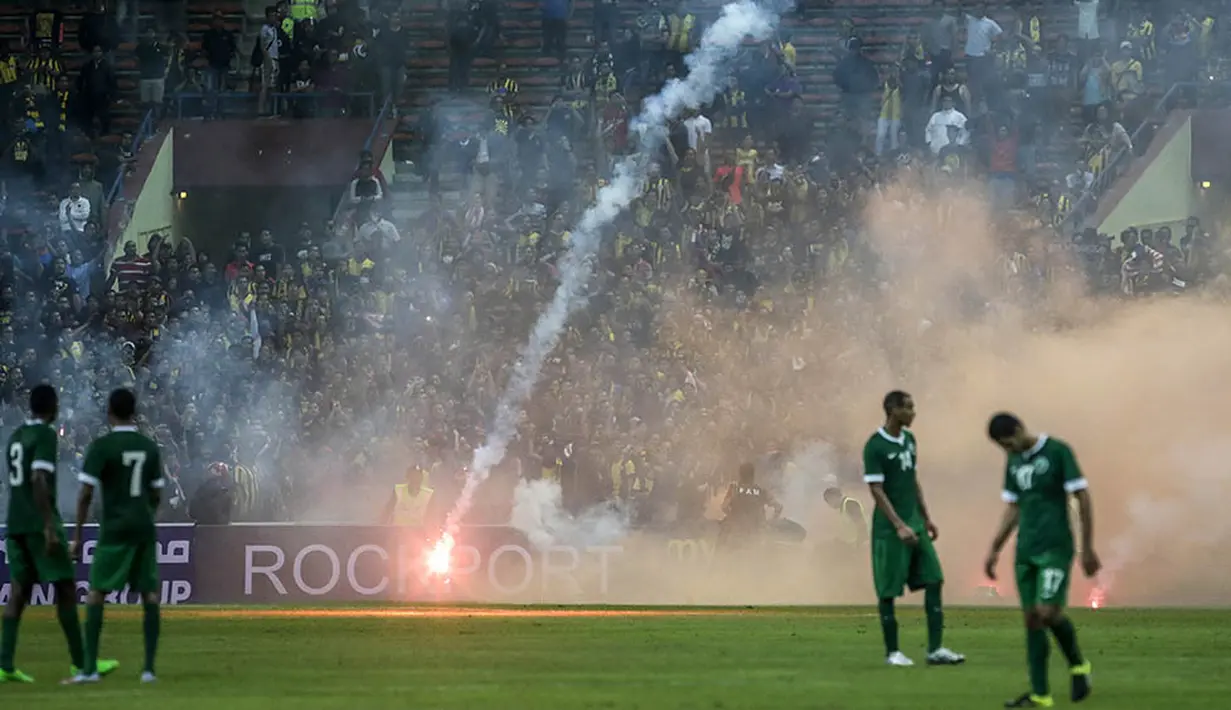 Suporter Malaysia melemparkan suar saat laga penyisihan Piala Dunia melawan Arab Saudi. Hal ini terjadi karena kekecewaan masyarakat Malaysia karena timnasnya kerap kalah telak. (EPA/Fazry Ismail)