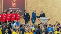 Presiden Rusia Vladimir Putin berjabat tangan dengan Presiden FIFA, Gianni Infantino usai memperlihatkan trofi Piala Dunia dalam pembukaan upacara  "FIFA World Cup Trophy Tour" di stadion Luzhniki di Moskow (9/9). (AFP Photo/Mladen Antonov) 