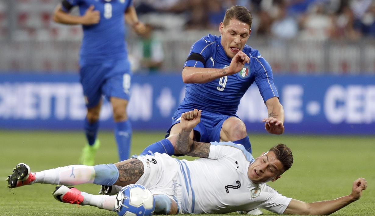 Pemain Italia, Andrea Belotti diadang pemain Uruguay,  Jose Gimenez (bawah)  pada laga Persahabatan di Nice Allianz Riviera stadium, Prancis, (7/6/2017). (AP/Claude Paris)