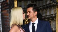 Penyanyi Katy Perry mencium pacarnya Orlando Bloom saat menghadiri pemutaran perdana untuk serial televisi "Carnival Row" di Los Angeles, California, AS (21/8/2019). Katy Perry tampil cantik mengenakan gaun seksi berwarna pink dengan rambut pirangnya yang di bob. (AFP Photo/Valerie Macon)
