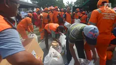 Petugas Penangganan Prasarana dan Saran Umum (PSSU) atau pasukan oranye mendapatkan sembako gratis di Jakarta, Jumat (3/8). Pembagian sembako gratis tersebut dalam rangka menyambut HUT ASABRI ke-47 tahun. (Merdeka.com/Imam Buhori)