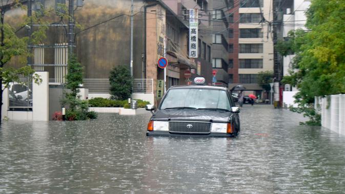 Sebuah taksi terjebak banjir di Saga, Jepang, Rabu (28/8/2019). Sejumlah lokasi rawan banjir dan tanah longsor di Jepang saat ini mencakup Saga, Fukuoka, dan Nagasaki di utara Kyushu. (Kyodo News via AP)