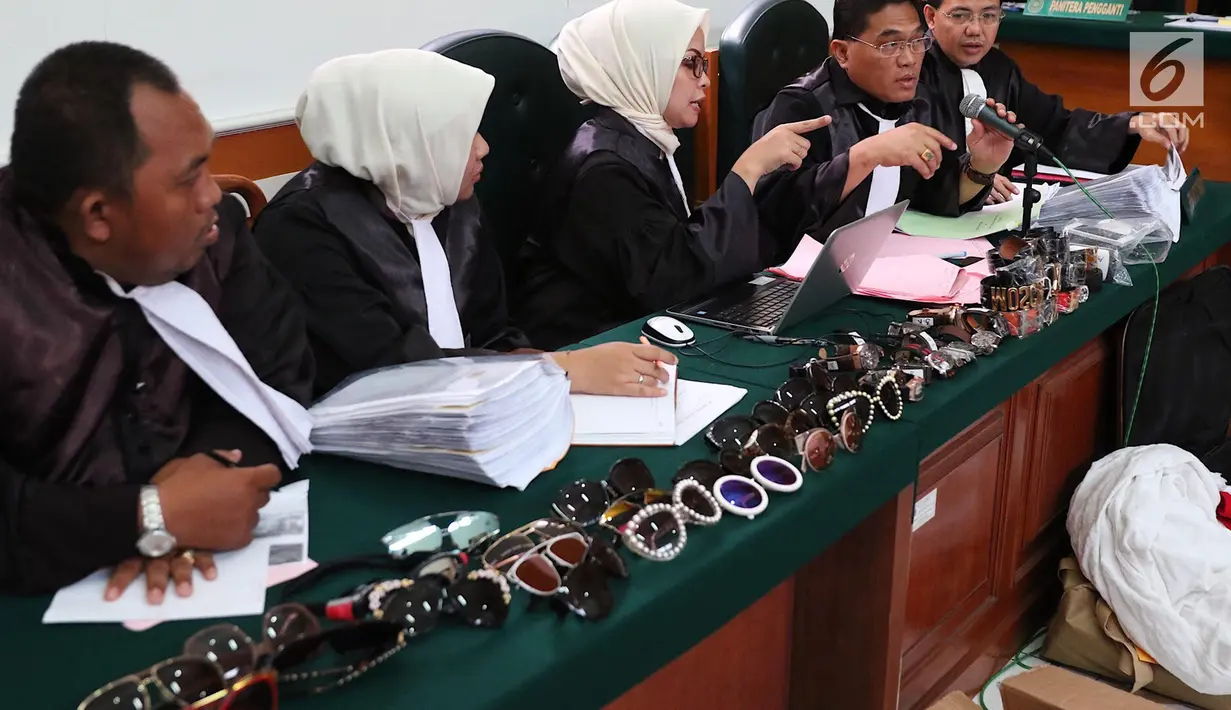 Jaksa menunjukkan barang-barang mewah milik Anniesa Hasibuan dan Andika Surachman dalam sidang lanjutan di Pengadilan Negeri Depok, Rabu (21/3). Terkait kasus ini, polisi menyita 116 kacamata bermerek dan 32 ikat pinggang. (Liputan6.com/Immanuel Antonius)