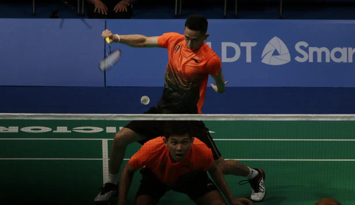 Ganda putra Indonesia, Fajar Rian / Muhammad Rian, mengembalikan kok saat melawan Aaron Chia / Soh Wooi Yik pada final beregu SEA Games 2019 di Multinlupa Sport Center, Rabu (4/12). Fajar / Rian kalah 17-21 dan 13-21. (Bola.com/M Iqbal Ichsan)