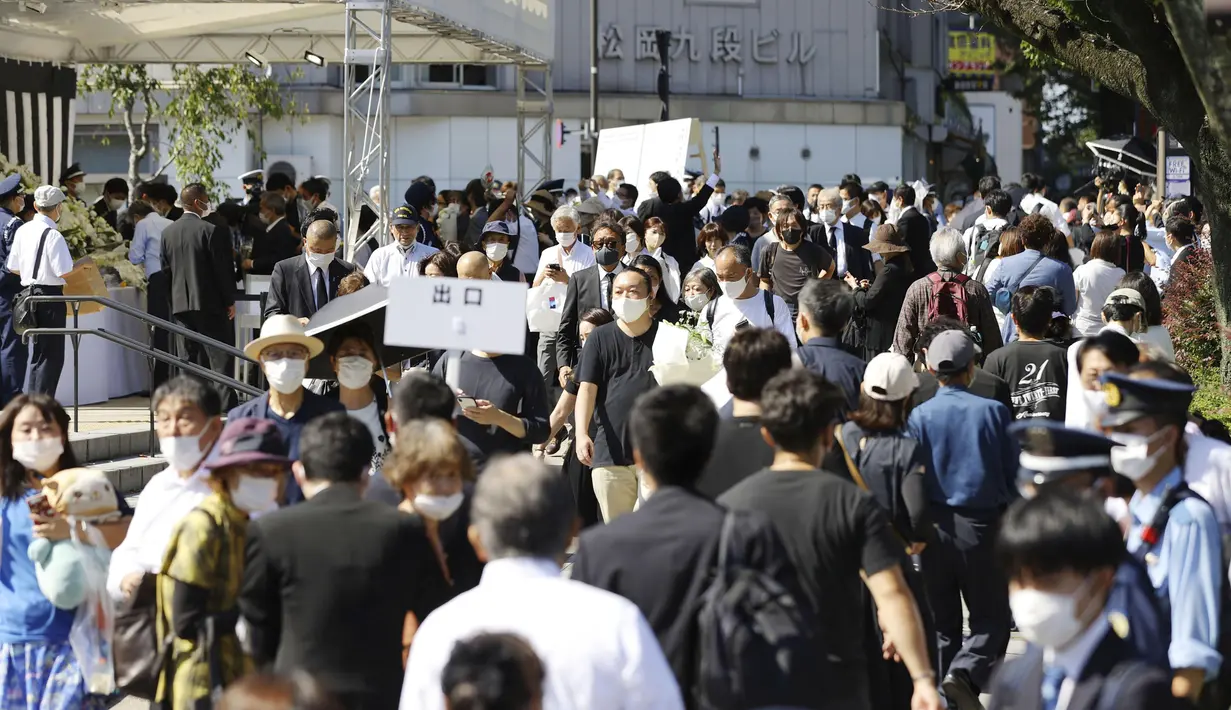Orang-orang mengantre untuk meletakkan bunga dan memberi penghormatan kepada mantan Perdana Menteri Jepang Shinzo Abe menjelang pemakaman kenegaraannya di Tokyo, Selasa, 27 September 2022. Sejumlah pemimpin negara asing hingga tamu VIP lainnya akan menghadiri upacara pemakaman itu. (Kyodo News via AP)