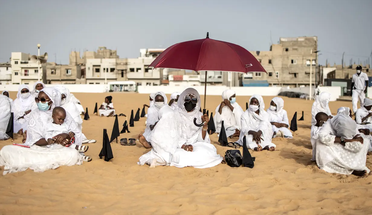 Pengikut komunitas Layene Senegal menunggu dimulainya salat Tabaski (Idul Adha) di lingkungan populer Yoff di Dakar, Rabu (21/7/2021). Para jemaah mengenakan pakaian putih untuk merayakan hari raya umat Muslim yang dikenal di Senegal sebagai 'Tabaski'. (JOHN WESSELS / AFP)