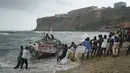 Warga bekerja sama menarik perahu yang terbalik ke daratan di pantai tempat beberapa orang ditemukan tewas di Dakar, Senegal, Senin (24/7/2023).  (AP Photo/Leo Correa)