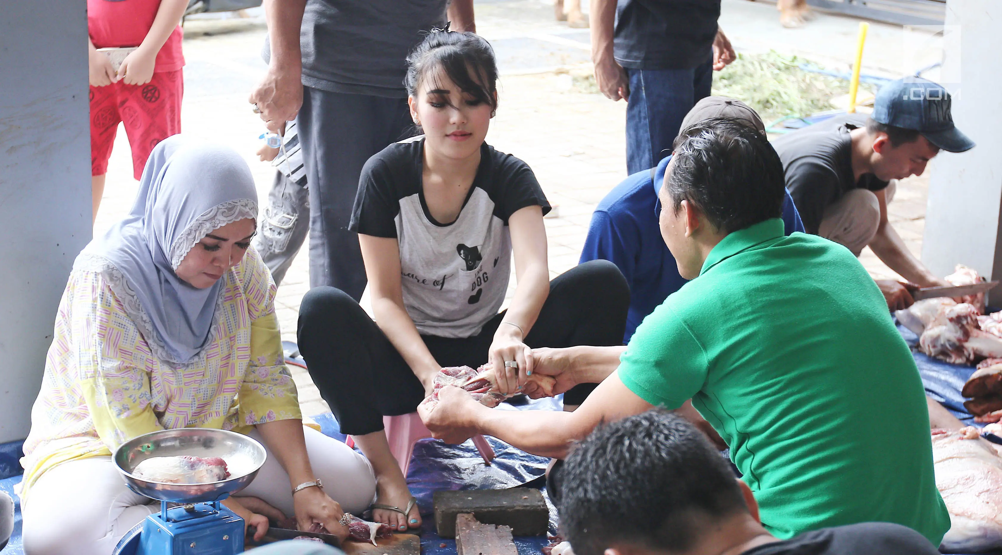 Penyanyi dangdut Ayu Ting Ting ikut memotong daging kurban ditemanin ibunya Umi Kalsum di kediamannya, Depok (1/9). Pada tahun ini Ayu Ting Ting berkurban sapi sebanyak 3 ekor di kediamannya. (Liputan6.com/Herman Zakharia)