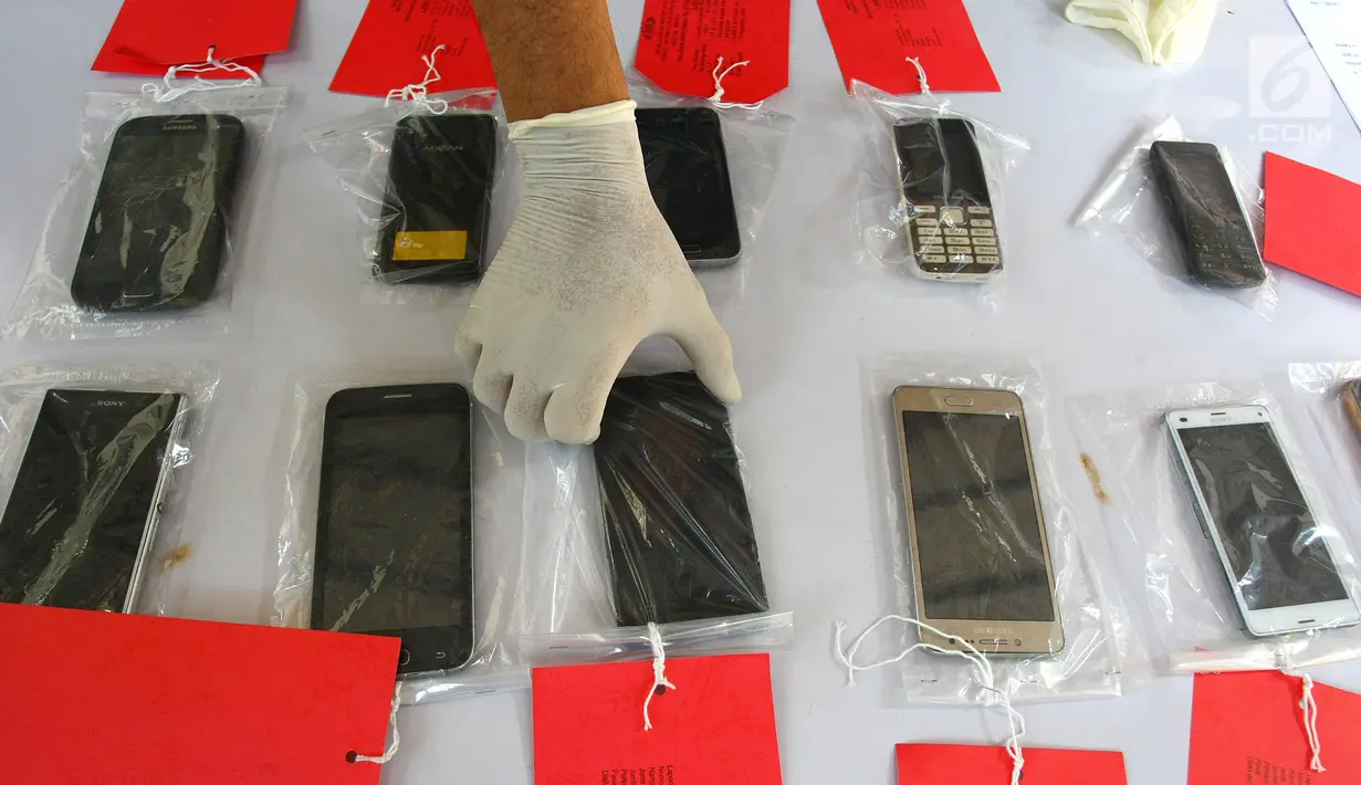Polisi menunjukkan barang bukti handphone di Mapolsek Benda, Tangerang, Banten, Senin (19/11). Polisi menangkap otak pelaku kejahatan spesialis handphone dan tiga tersangka lainnya. (Liputan6.com/Fery Pradolo)