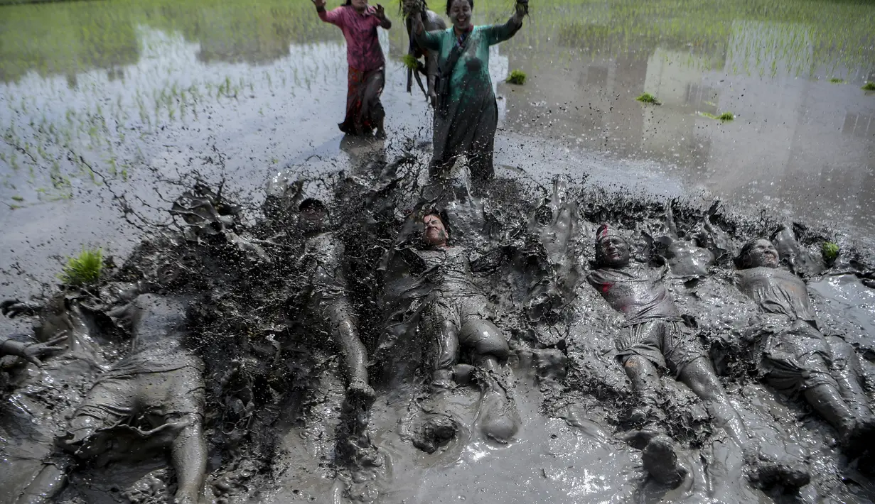 Petani bermain lumpur saat memeriahkan Hari Padi Nasional di desa Tokha di pinggiran Kathmandu, Nepal, Selasa (29/6/2021). Peringatan Hari Padi Nasional yang juga disebut Asar Pandra ini ditandai dengan dimulainya penanaman padi di sawah saat musim hujan. (AFP/Prakash Mathema)