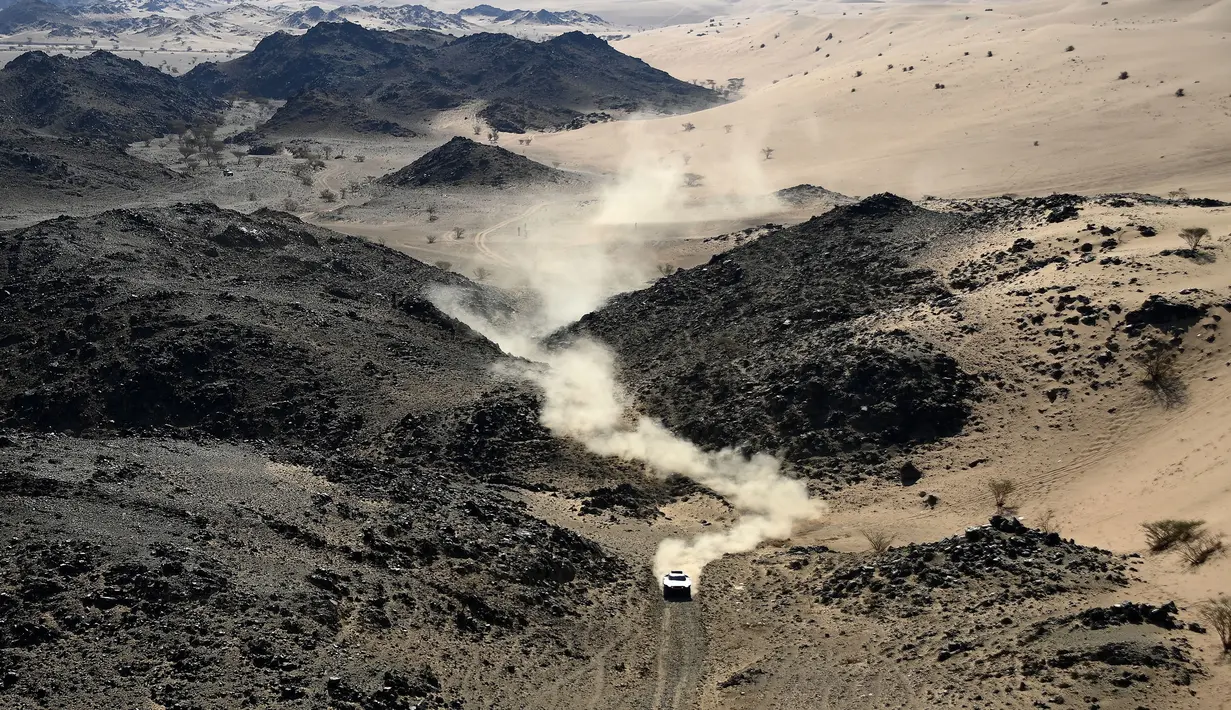 Pembalap kendaraan listrik Audi asal Prancis, Stephane Peterhansel dan co-drivernya Edouard Boulanger dari Prancis bersaing selama Stage 1A Reli Dakar 2022 antara Jeddah dan Hail, di Arab Saudi, pada 1 Januari 2022. (AFP/Franck Fife)