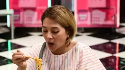 Seorang wanita makan mie instan untuk makan siang di toko Good Noodle yang menjual berbagai macam mie instan dari seluruh Asia, di Bangkok (25/8/2022). Thailand akan menaikkan harga mie instan Thailand, kata departemen perdagangan 24 Agustus menandai kenaikan harga pertama pada kebutuhan pokok harian dalam 14 tahun. (AFP/Vatsyayana)