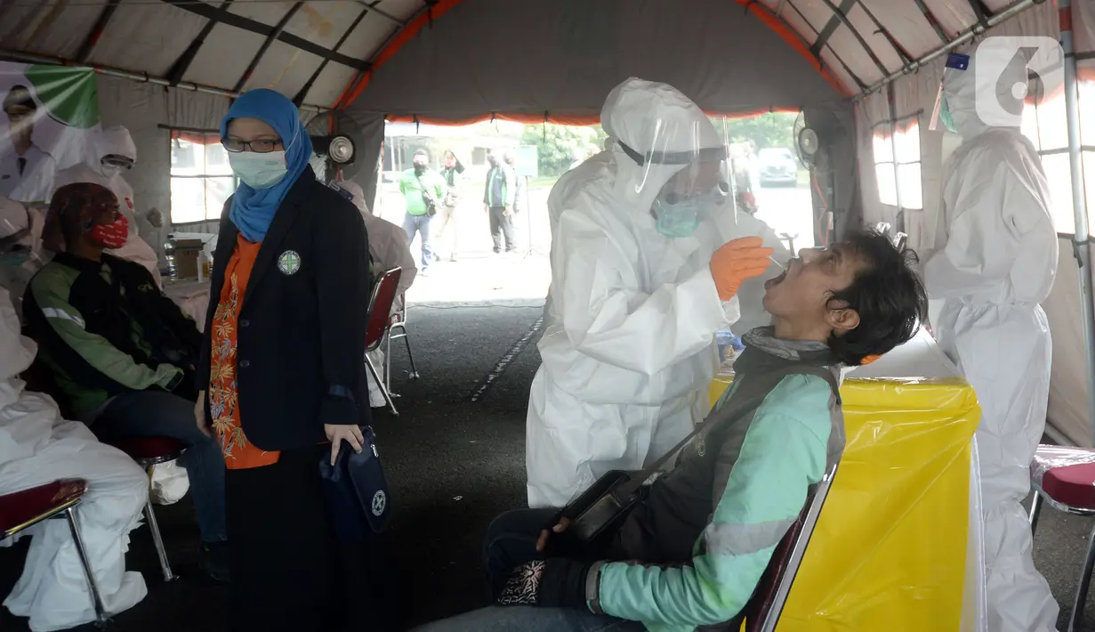 Petugas medis melakukan swab test COVID-19 terhadap pengemudi ojek online di Alam Sutra, Tangerang Selatan, Banten, Selasa (21/7/2020). Swab test gratis tersebut digelar di tengah kasus COVID-19 yang terus bertambah di beberapa daerah di Indonesia. (merdeka.com/Dwi Narwoko)