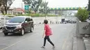 Warga menyeberang jalan di depan Stasiun Pasar Minggu, Jakarta, Rabu (16/10/2019). Jauhnya jembatan penyeberangan orang (JPO) membuat warga memanfaatkan celah pagar pembatas tersebut sebagai akses menyeberang, meski berbahaya bagi keselamatan. (Liputan6.com/Immanuel Antonius)
