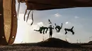 Empat pemuda Palestina mempraktekkan keterampilan parkour mereka di dekat tenda warga di perbatasan Gaza, Palestina (10/4). Mereka menghibur para warga yang melakukan aksi protes di perbatasan Gaza tersebut. (AFP Photo/Said Khatib)