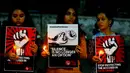 Sejumlah wanita India memegang lilin sambil menunjukkan poster saat aksi protes kasus perkosaan di Ahmadabad, India (16/4). (AP Photo / Ajit Solanki)