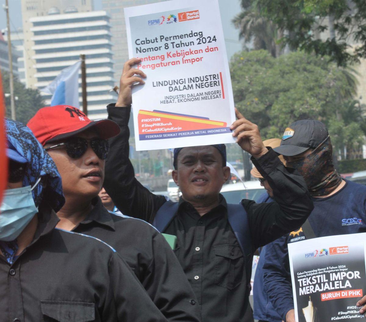 Massa buruh menggelar aksi unjuk rasa di Kawasan Patung Kuda, Jakarta, Rabu (3/7/2024). <br><br>Aksi tersebut mereka lakukan untuk menuntut kepada pemerintah soal penghentian ancaman PHK puluhan ribu buruh. Foto: merdeka.com / imam buhori <br>