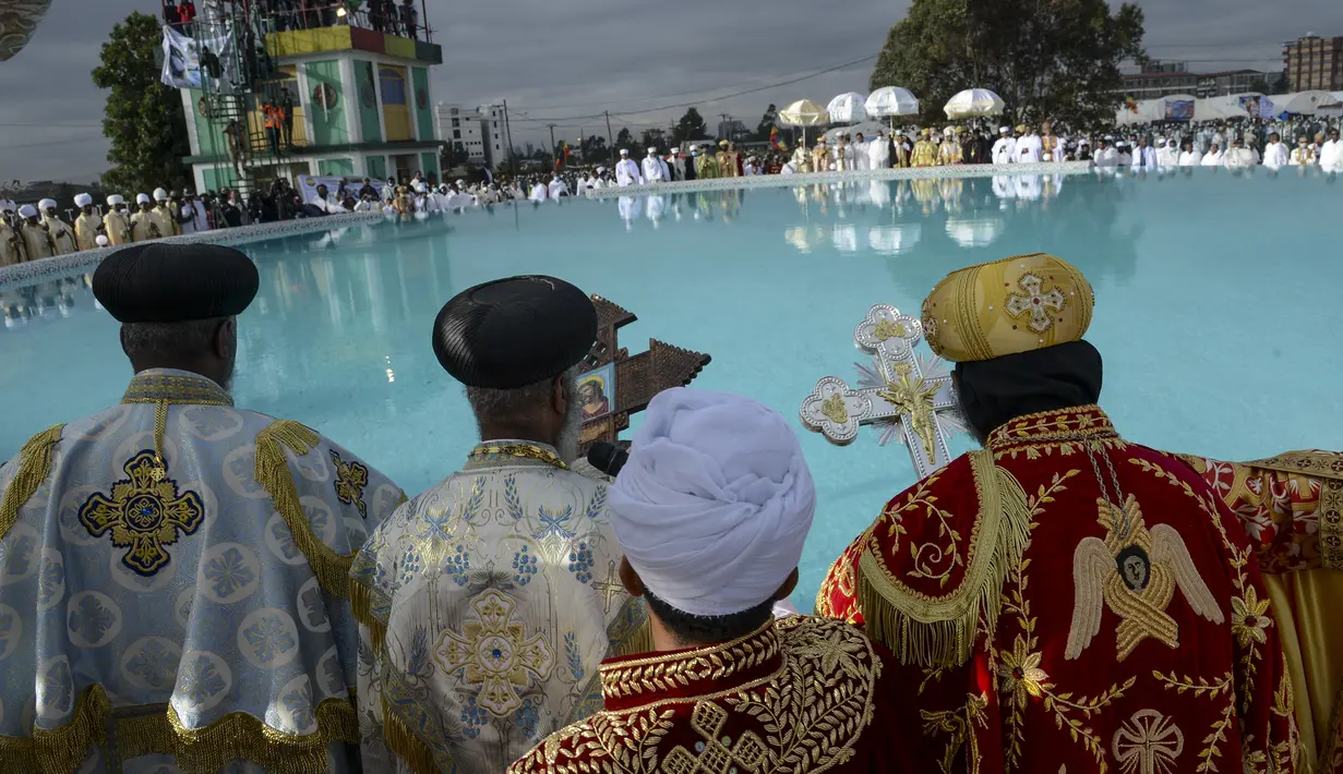 Para imam Kristen Ortodoks Ethiopia berkumpul di sebelah kolam air saat para pengikutnya menabuh genderang dan menyanyikan lagu-lagu religi untuk merayakan hari kedua festival Timkat, atau Epiphany, di ibu kota Addis Ababa, Ethiopia, Rabu (19/1/2022). (AP Photo)