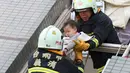 Petugas penyelamat mengevakuasi seorang bayi yang selamat akibat gempa di Tainan, Taiwan Selatan (6/2). Gempa terjadi pukul 4 subuh tadi telah menghancurkan beberapa apartemen di kawasan Wei Guan, Tainan, Taiwan. (REUTERS/Stringer)