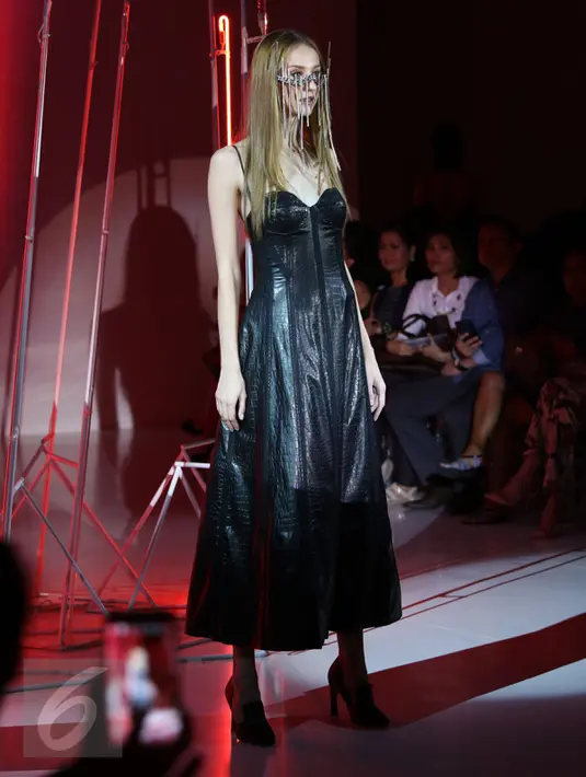 Model berpose mengenakan baju hitam dengan asksesoris di wajah koleksi Desainer Stella Rissa dalam peragaan busana IPMI Trend Show 2017 di Senayan City, Jakarta (9/11). (Liputan6.com/Gempur M. Surya)