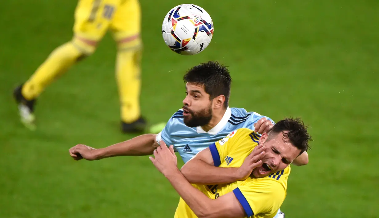 Bek Celta Vigo, Nestor Araujo, berebut bola dengan penyerang Cadiz, Alvaro Gimenez, pada laga lanjutan Liga Spanyol di Stadion Abanca Balaidos, Selasa (15/12/2020) dini hari WIB. Celta Vigo menang telak 4-0 atas Cadiz. (AFP/Miguel Riopa)