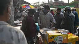 Orang-orang membeli kurma di sepanjang jalan menjelang bulan suci Ramadhan di Delhi, India pada Selasa (13/4/2021). Kurma sangat identik dengan bulan Ramadhan, karena buah yang satu ini kerap dijadikan pengisi menu sahur dan berbuka puasa. (Sajjad HUSSAIN / AFP)