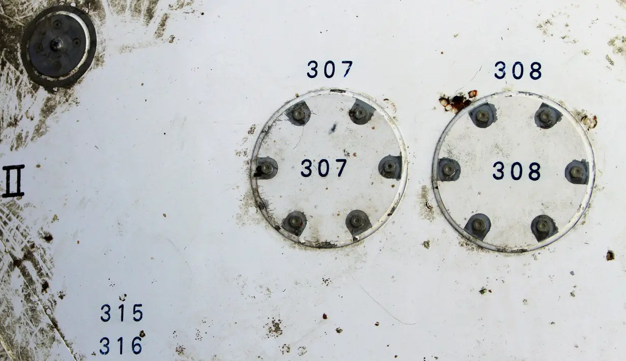 Kondisi potongan pesawat yang ditemukan di pantai Thailand selatan, provinsi Nakhon Si Thammarat, Minggu (24/1). Di bagian puing yang diduga dari pesawat Malaysia Airlines MH370 tersebut tercetak angka 307 dan 308. (REUTERS/Surapan Boonthanom)