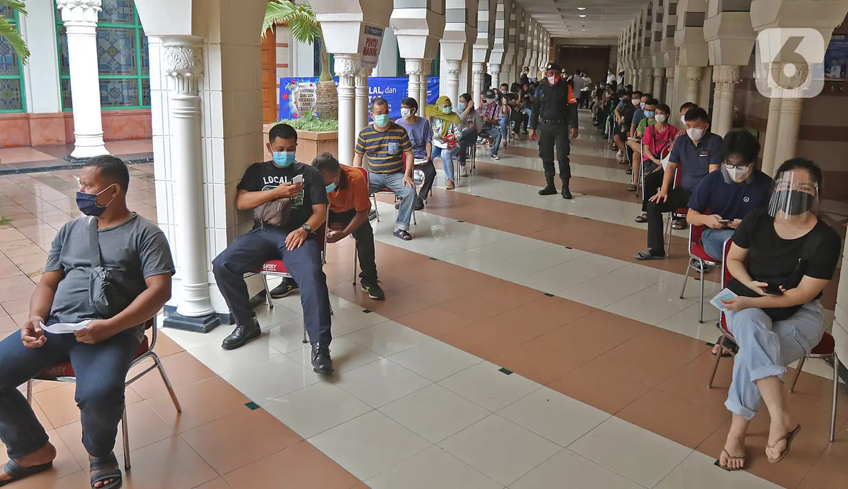 Pedagang saat antre untuk menjalani vaksinasi COVID-19 di Pasar Tanah Abang Blok A, Jakarta, Rabu (17/2/2021). Vaksinasi COVID-19 tahap kedua yang diberikan untuk pekerja publik dan lansia itu dimulai dari pedagang Pasar Tanah Abang di blok A, B, F, dan G. (Liputan6.com/Herman Zakharia)