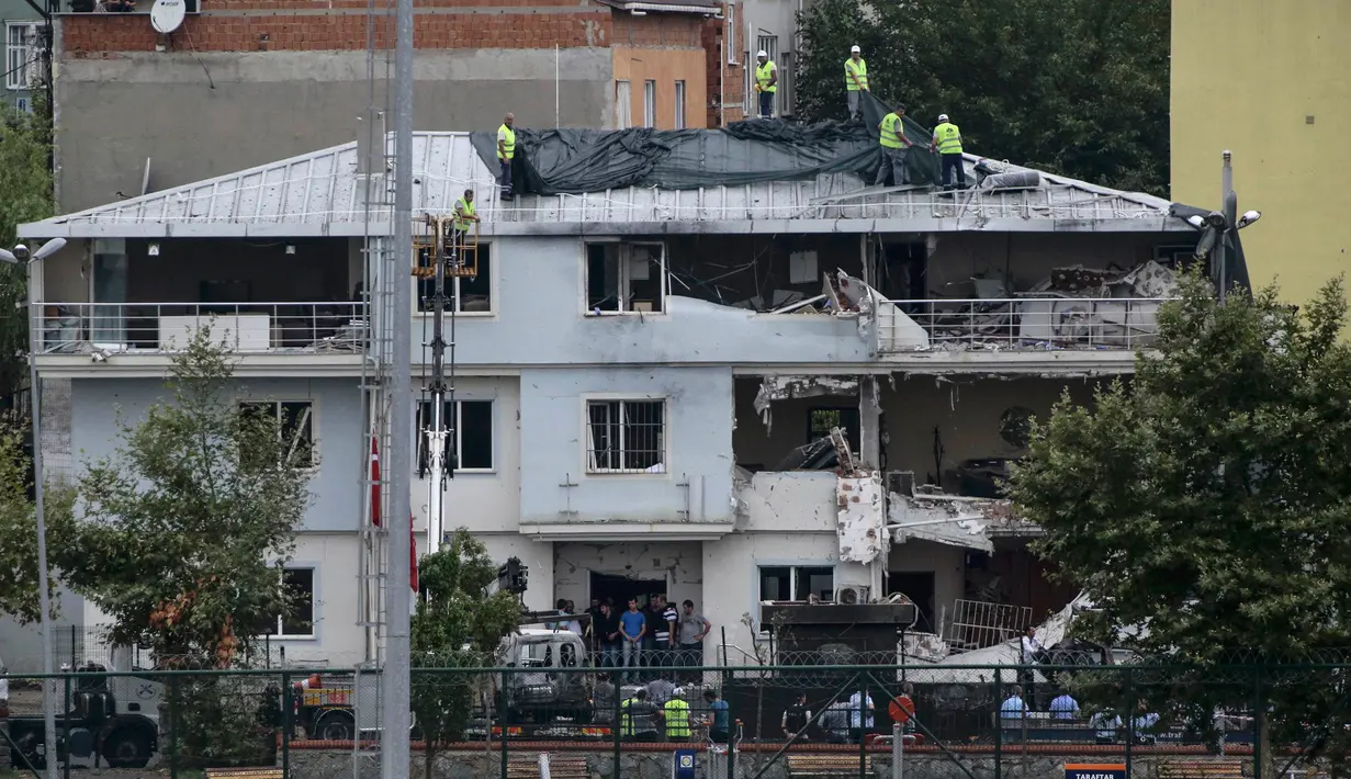 Sejumlah petugas menutupi kantor polisi dengan kain di Istanbul usai dibom, Senin (10/8/2015). Sebuah truk bermuatan bahan peledak membombardir kantor polisi yang melukai tiga anggota dan tujuh warga sipil. (REUTERS/Huseyin Aldemir)